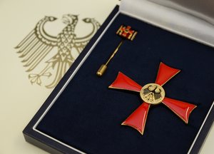 Ein Bundesverdienstkreuz (rotes Kreuz mit goldenem Punkt in der Mitte). Foto: Judith Wedderwille/ Kreis Soest