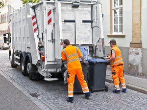Zwei Männer von der Müllabfuhr entleeren Mülleimer. Foto: © eyetronic - Fotolia.com