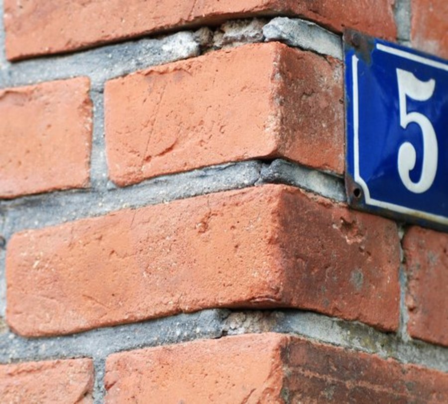 Hausnummer 5 auf roter backsteinmauer. Foto: © pholidito fotolia