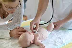Baby wird von Kinderarzt untersucht. Foto: © Bernd Libbach - Fotolia.com